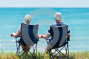 Family man and woman relax and unwind in camping chairs
