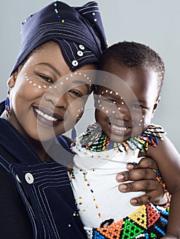 Family means everything in our culture. Studio portrait of a cheerful middle aged woman holding her baby daughter while