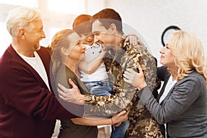 The family meets a man in camouflage at home.