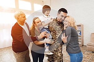 The family meets a man in camouflage at home.