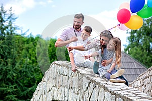 Family members bent on the side of the stone bridge