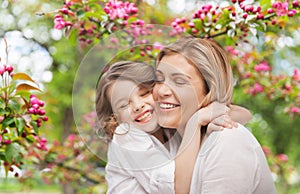 Happy mother and daughter hugging over garden photo