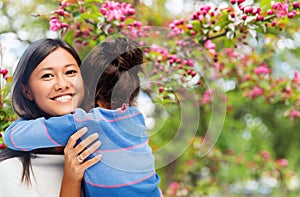 Happy mother and daughter hugging over garden photo