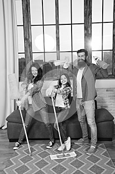 Family mom dad and daughter with cleaning supplies at living room. We love cleanliness and tidiness. Cleaning together