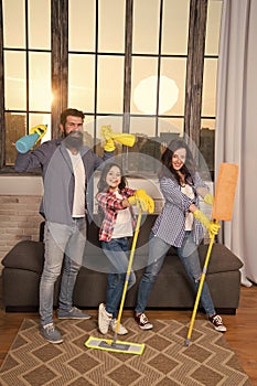 Family mom dad and daughter with cleaning supplies at living room. We love cleanliness and tidiness. Cleaning together