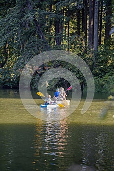 Family mom dad and son have fun kayaking on the picturesque Round Lake in Lakamas forest