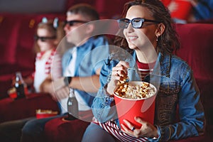 Family mom father and children are watching a projector, TV, cinema, movies with popcorn in the cinema.