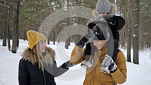 Family, mom, son and dad are walking tigether in winter park.