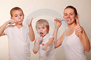 Family mom two blond boys brush their teeth home