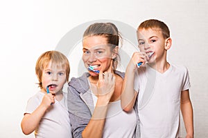 Family mom two blond boys brush their teeth home