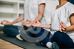 family moment a mother and her little daughter meditate and practice yoga in