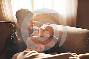 Family, morning and father with baby on sofa for bonding, relationship and care for parenting. Happy, home and dad with