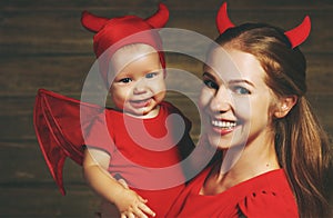 Family mother and baby son celebrate Halloween in devil costume