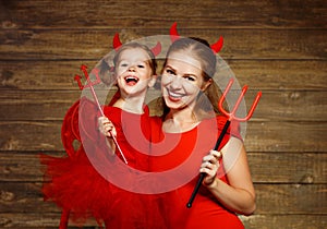 Family mother and child daughter celebrate Halloween in devil co