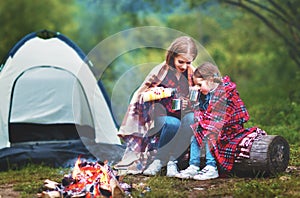 Family mother and child daughter drinking tea on a camping trip