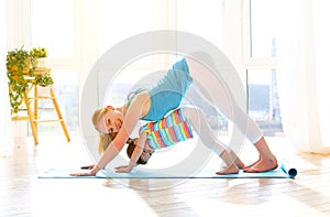 Family mother and child daughter are engaged in fitness, yoga at