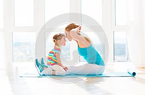 Family mother and child daughter are engaged in fitness, yoga at