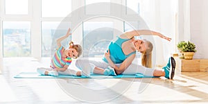 Family mother and child daughter are engaged in fitness, yoga at