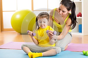 Family mother and child daughter are engaged in fitness, yoga, exercise at home or sport hall