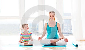 Family mother and child daughter are engaged in meditation and y