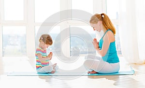 Family mother and child daughter are engaged in meditation and y