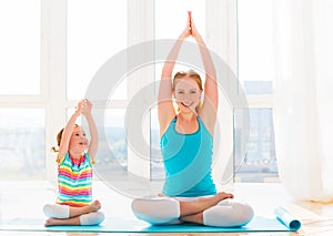 Family mother and child daughter are engaged in meditation and y