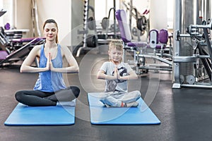 Family mother and child daughter are engaged in meditation and yoga