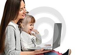 Family mother and child daughter at home with a laptop