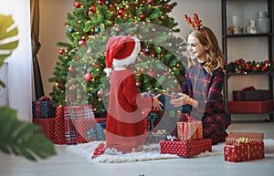 Family mother and child daughter open presents on Christmas mo