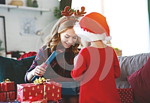 Family mother and child daughter open presents on Christmas mo