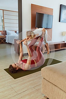 Family. Mother And Child Exercising Together At Home. Young Woman And Daughter Doing Partner Yoga. Sporty Kid And Parent