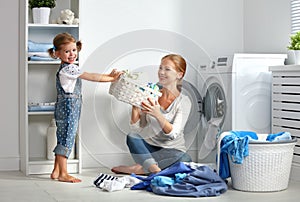 Family mother and child little helper in laundry room near washi