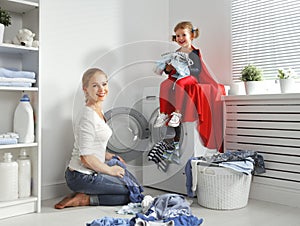 Family mother and child little superhero helper in laundry room