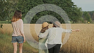 Family mother and children two daughters walking together along country road, back view