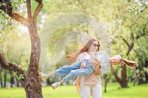 Family of mother and daughter in blooming cherry garden