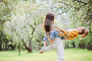 Family of mother and daughter in blooming cherry garden