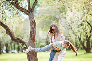 Family of mother and daughter in blooming cherry garden