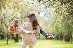 Family of mother and daughter in blooming cherry garden