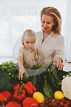 Family mother and daughter child cooking healthy food vegetables ingredients vegan sustainable lifestyle