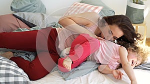 Family, mother and daughter are fooling around on bed