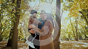 Family of mother father and boy spends time in autumn forest