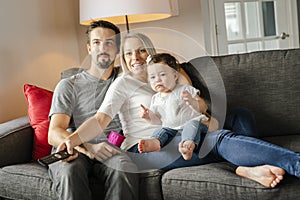 Family mother, father, child daughter at home watching tv