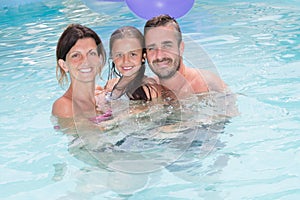 Family mother and father with daughter in vacation pool portrait
