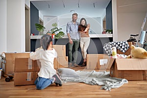 Family- mother father and girl move to new apartment and unpack boxes