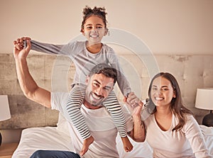 Family, mother and father with happy girl sitting in bedroom together spending quality time relaxing at home. Smile