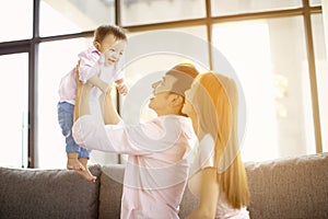 family mother and father playing with baby at home