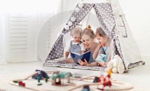 Famiglia madre lettura sul un libro una tenda sul 