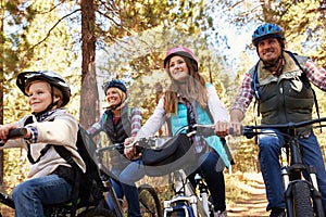 Family mountain biking in a forest, low angle front view