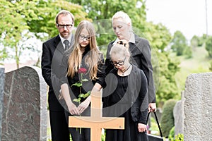 Family mourning at grave on cemetery