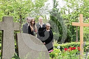 Family mourning at grave on cemetery
